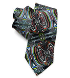 Fordite necktie: A rolled and laid-flat necktie featuring a complex, psychedelic abstract pattern with swirling concentric shapes in black, white, red, green, blue, and orange on a white background.