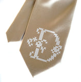 Cyberoptix initial print tie. Cross-Stich font, white on champagne.