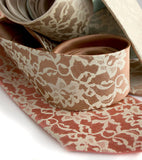 Lace print necktie. Ivory-cream ink on pale copper, dark salmon.