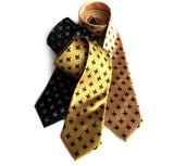 Fleur de lis ties. L to R: black; gold; honey.