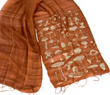 Ivory-cream ink on cinnamon silk scarf.